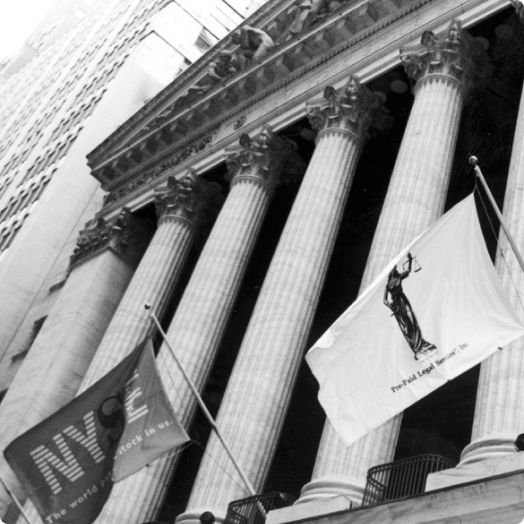 NYSE & Pre-Paid Legal Services, Inc. flags flying in front of the New York Stock Exchange building in New York City in 1999.